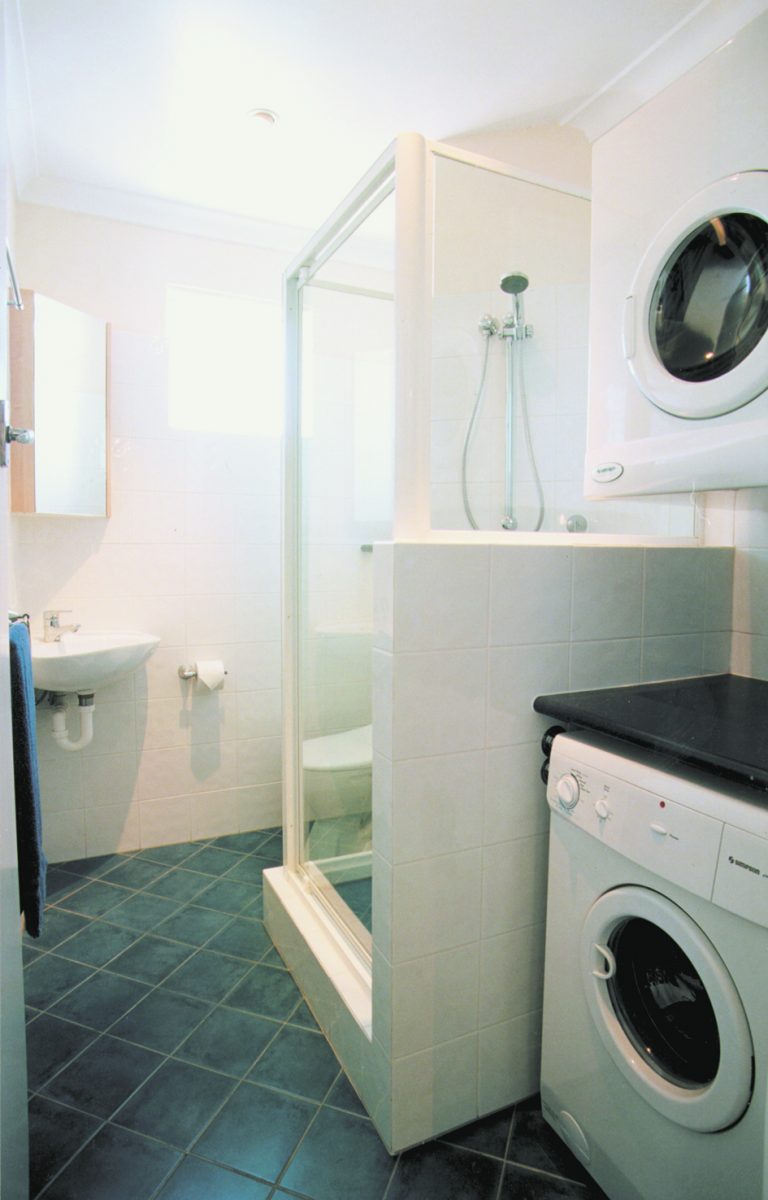 bathroom fitted loads in to small space including washer dryer and bench